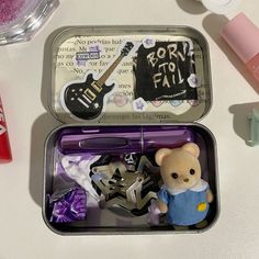 an open lunch box with toys and other items in it on a white table top