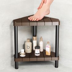 a person's bare foot on top of a shelf with cosmetics and lotion