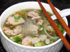 a white bowl filled with soup next to chopsticks