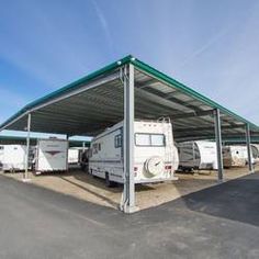 a group of rvs parked under a metal structure