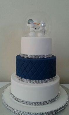 a three tiered cake with blue and white frosting on it's sides