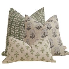 three pillows with different designs on them, one in green and the other in beige