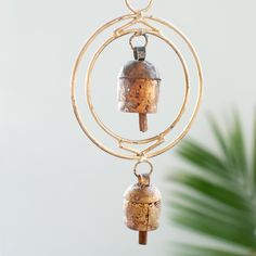 a metal object hanging from a wire with a ring around it and two bells attached to it