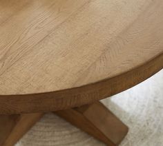 a close up view of a wooden table with white carpet on the floor in front of it