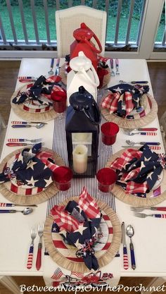 a patriotic table setting with red, white and blue napkins on the place settings