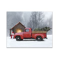 an old red truck with a christmas tree in the bed is parked near a cabin