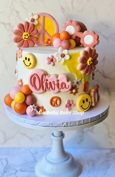 a white cake with flowers and smiley faces on it