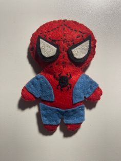 a spiderman stuffed animal hanging on the wall