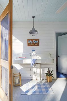 an open door leading to a bathroom with white walls and wood flooring on the outside