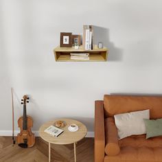 a living room with a couch, coffee table and musical instruments on the wall above it