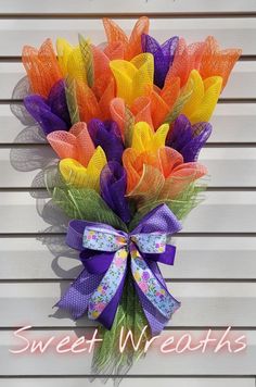 a bouquet of colorful tulle flowers with the words sweet wreaths on it