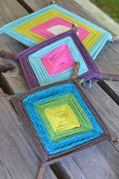 three square crocheted coasters sitting on top of a wooden table