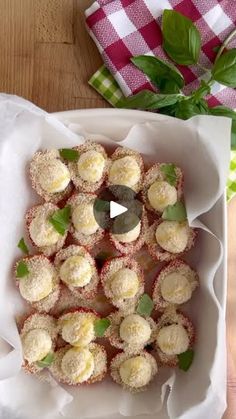 a white plate topped with mini desserts covered in powdered sugar and green leaves