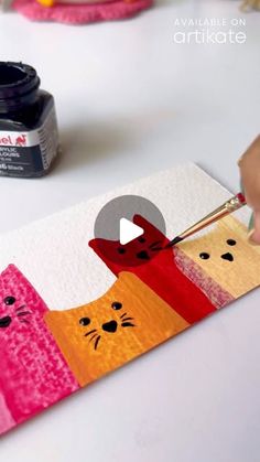 someone is painting an image on a piece of paper that looks like cats and kittens