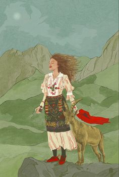 a woman standing on top of a mountain next to a goat