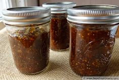 three jars filled with food sitting on top of a table