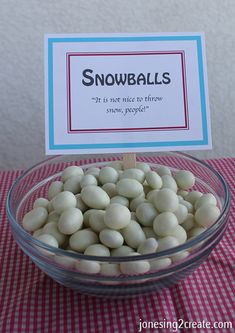 a bowl filled with white snowballs sitting on top of a red checkered table cloth