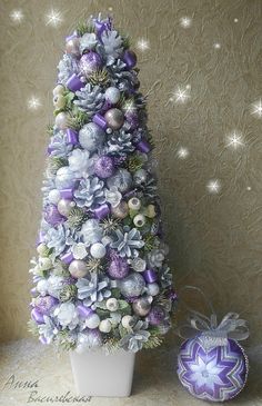 a decorated christmas tree sitting on top of a table next to a purple ornament