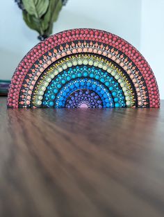 a wooden table topped with a rainbow shaped object