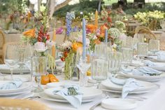 the table is set with white plates and place settings