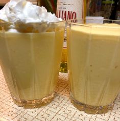 two glasses filled with liquid sitting on top of a table