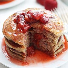 pancakes with strawberries and syrup on white plates