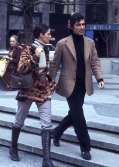 a man and woman walking down some steps