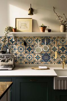 a kitchen counter with pots and pans hanging on it's wall above the sink