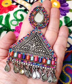 Turn heads wearing this unique and colorful large German silver triangular Afghani earrings with mirror stud and mirror dangles. Colorful seed beads. Fabric backed for comfort Weight 29 gm. find even more great earrings here: https://www.etsy.com/shop/boutiquebymaryam?section_id=22797814 Shop BoutiqueByMaryam: https://www.etsy.com/shop/boutiquebymaryam All my jewelry is boxed and wrapped to be ready for gift giving. I'm happy to ship directly to your recipient. Thank you for your support! Bohemian Triangle-shaped Jewelry For Festivals, Silver Beaded Earrings With Dangling Beads For Festival, Bohemian Earrings With Silver Beads For Festivals, Silver Beaded Earrings With Colorful Beads For Festival, Bohemian Triangle Jewelry With Dangling Beads, Silver Teardrop Beaded Earrings Bohemian Style, Bohemian Silver Teardrop Beaded Earrings, Silver Metal Beaded Earrings For Festivals, Traditional Metal Beaded Earrings For Festivals