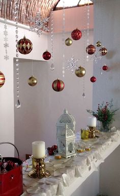 a long table with ornaments hanging from it's ceiling and candles on the tables