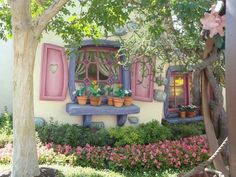 a house with potted plants in front of it and a window on the side