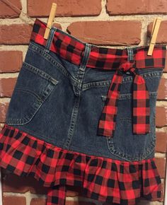 a red and black plaid skirt hanging on a brick wall