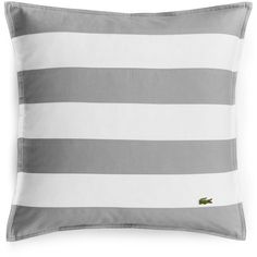 a gray and white striped pillow with a small alligator on it