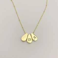 "14k solid yellow gold necklace with a 3 teardrops pendant with black diamonds and engraved letters, layered solid gold necklace for women. This 14k yellow gold necklace has 3 teardrop pendants. One of the pendants has black diamonds on the back and the other 2 have one engraved letter each. This necklace is light and shiny, perfect for everyday use. It will complement any look you choose whether it is classic, boho-chic, street style, and more... You can wear it as a single, minimalist necklace 14k Yellow Gold Teardrop Charm Necklaces, Gold Sterling Silver Teardrop Charm Necklaces, Teardrop 14k Yellow Gold Charm Necklaces, Gold Drop Necklaces In 14k Gold, Gold Sterling Silver Drop Necklace For Anniversary, Gold Teardrop Jewelry Stamped 14k, Personalized Gold Teardrop Jewelry, Personalized Drop Jewelry For Anniversary, Personalized Drop Jewelry For Anniversaries