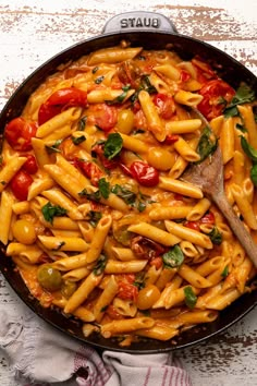 a skillet filled with pasta and tomatoes