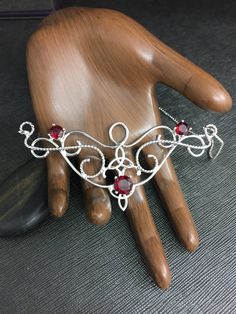 I love Victorian themed jewelry with an Edwardian, Elvish-inspired flair, and I hope I've captured it within this piece! I shall custom create this gorgeous Renaissance style necklace, in sterling silver, with three faceted gemstones of your choosing in the drop-down menu. I've shown garnet here in the images displayed. The center gemstone is 8mm round and the two sides are 4mm round. The chain will be soldered to each side and I will use a 1.2mm thick sterling box chain. I think this piece look Fantasy Style Silver Jewelry With Unique Design, Hand Forged Fantasy Jewelry As A Gift, Fantasy Style Hand Forged Jewelry As Gift, Adjustable Red Fantasy Jewelry, Red Crown Jewelry For Wedding, Fantasy Jewelry With Unique Design For Gift, Fantasy Wire Wrapped Jewelry As Gift, Fantasy Wire Wrapped Jewelry Gift, Fantasy Style Wire Wrapped Jewelry Gift