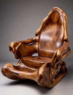 a wooden chair made out of wood with carvings on the armrests and back