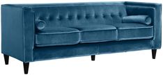 a blue velvet couch with wooden legs