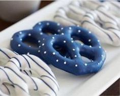 three pretzels on a white plate with blue and white icing