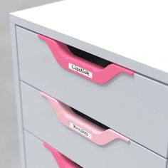 two drawers with pink handles and labels on the top one drawer is gray and the second drawer has pink handles