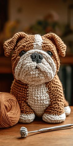 a crocheted dog sitting on top of a table next to a ball of yarn