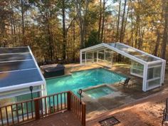 an aerial view of a swimming pool and hot tub in the middle of a wooded area