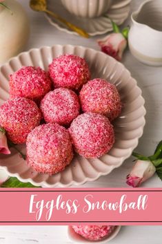 a bowl filled with powdered sugar covered donuts on top of a white table