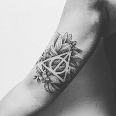 a black and white photo of a person's arm with a flower tattoo on it