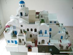 a model of a house with blue and white doors, windows, and balconies