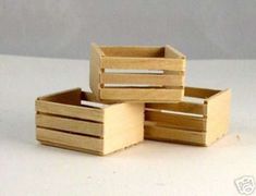 three wooden boxes sitting next to each other on a white counter top with one empty box in the middle