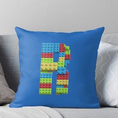 the letter f made out of lego blocks on a blue background throw pillow by pixelpix