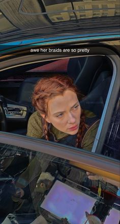 a woman sitting in the driver's seat of a car