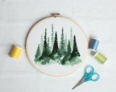 a cross - stitch pattern with some scissors and thread on the table next to it