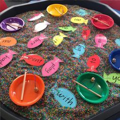 an assortment of colorful paper plates with words on them and knitting needles in the middle